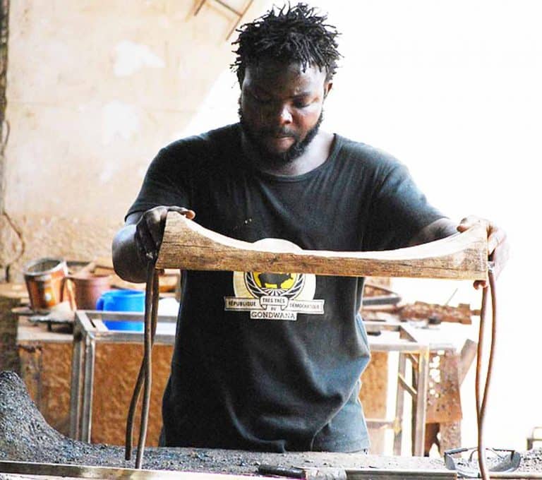 Realisation d'un tabouret en bois de palissandre et métal de récupération. Fait main au Burkina Faso.